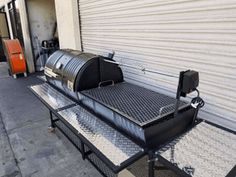 a bbq grill sitting on top of a metal table next to a garage door