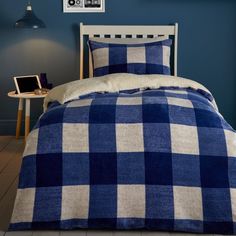 a blue and white checkered comforter on a bed