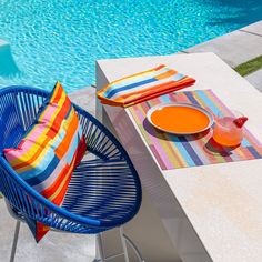 a blue chair sitting next to a pool with an orange plate on top of it