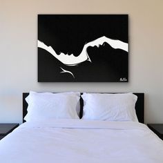 a bed with white sheets and pillows in a room next to a painting on the wall