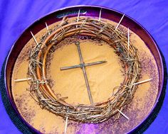 a cross is placed on top of a plate with sticks sticking out of the middle