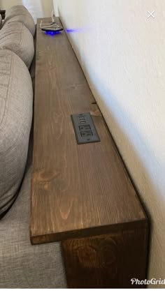 a couch with a remote control sitting on it's side next to a wall