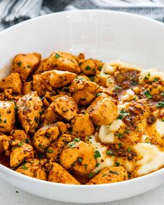 a white bowl filled with chicken and mashed potatoes