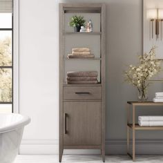 a white bath tub sitting next to a tall wooden shelf with towels on top of it