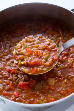 a ladle full of beans and carrots in a pot