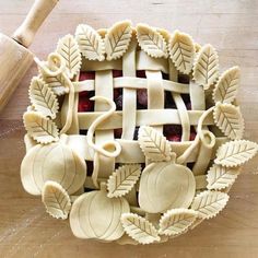 a pie crust with leaves and apples on it