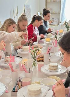 a group of people sitting around a table eating cake