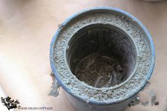 a bucket with dirt in it sitting on top of a table