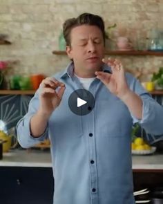 a man standing in front of a kitchen counter holding his hands out to the side