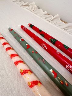 four christmas themed pens lined up on a bed