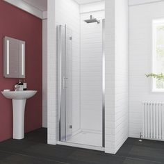 a bathroom with a sink, mirror and shower stall in it's corner area