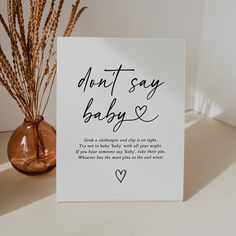 a card that says don't say baby on it next to a vase with dry grass