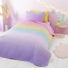 a bedroom with pink walls, white floors and a bed covered in a multicolored bedspread