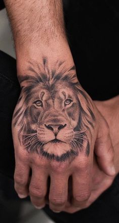 a man's hand with a lion tattoo on it