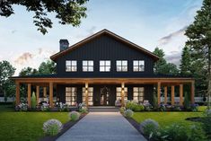 a black and white house with lots of windows on the front porch is lit up at night