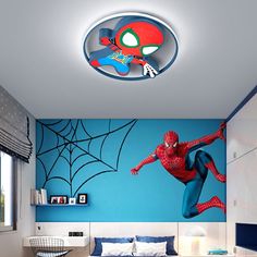 a bedroom with a spiderman mural on the wall