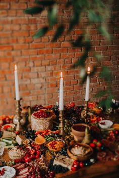 a table topped with lots of food and candles