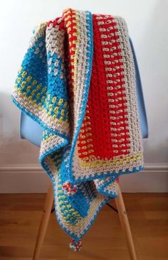 a crocheted blanket sitting on top of a chair