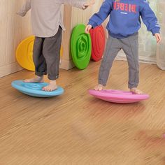 two young children playing with frisbees on the floor