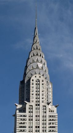 a very tall building with a clock on it's face in front of a blue sky