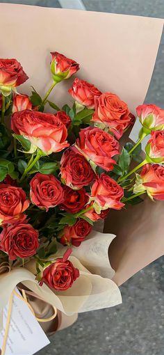 a bouquet of red roses sitting on top of a piece of paper