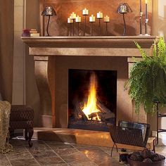 a living room with a fire place in the center and candles on the mantle above it