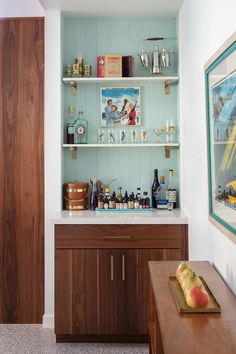 a kitchen with wooden cabinets and shelves filled with bottles