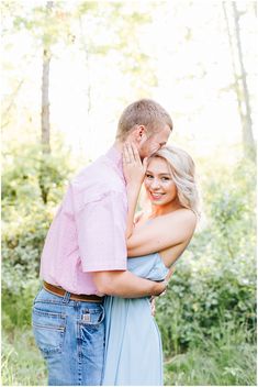 a man and woman embracing each other in the woods