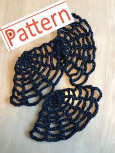 three pieces of black crochet sitting on top of a wooden table next to a sign that says pattern