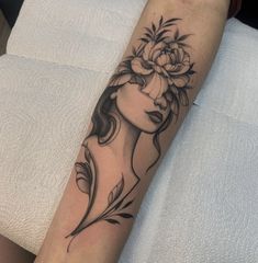 a woman's arm with a flower and leaves tattoo on the left side of her arm