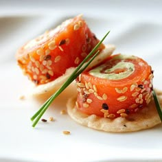 some kind of food that is on top of a white plate with green onions and sesame seeds