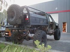 an off - road vehicle parked in front of a building with large tires on it