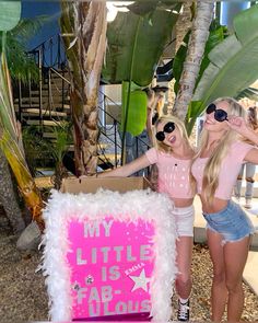 two girls standing next to a sign that says, my little is arr fabulous