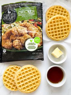 chicken and waffles are on the table next to two cups of tea