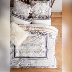 an overhead view of a bed with two pillows and blankets on top of the sheets