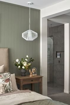 a bedroom with green walls and white flowers