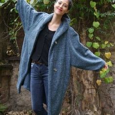 a woman standing in front of an apple tree with her arms outstretched and hands out to the side