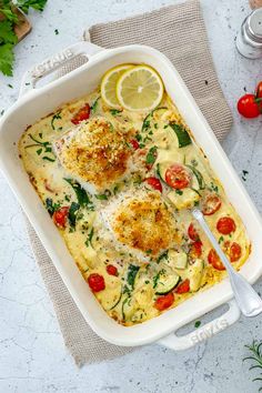 a casserole dish with chicken, tomatoes and spinach