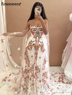 a woman is taking a selfie in a wedding dress with flowers all over it