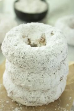 three doughnuts stacked on top of each other with powdered sugar around them