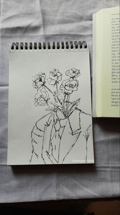 an open book with a drawing of flowers in it