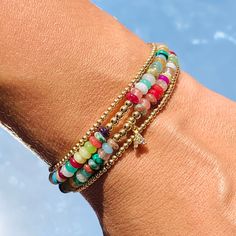 Our Gaby Beaded Bracelet is a harmonious fusion of vibrant hues and luxurious accents. This bracelet is a celebration of color, adorned with carefully selected beads that exude a lively charm. The rainbow of beads, each reflecting a different shade, creates a playful yet elegant palette that's perfect for brightening up your day. Amidst this burst of color, a delicate gold beads weaves its way, adding a touch of sophistication and warmth. Size: 7" + 2" Extension Does not include Initial Charm Colorful Beaded Bangle Bracelets For Friendship, Multicolor Gemstone Beaded Bangle Bracelets, Colorful Beaded Friendship Bangle, Multicolor Gemstone Beads Bangle Bracelet, Multicolor Bangle Charm Bracelet For Party, Rainbow Bangle Jewelry With Colorful Beads, Colorful Hand-strung Jewelry, Adjustable Rainbow Gemstone Beaded Bracelets, Multicolor Pearl Bracelet With Spacer Beads