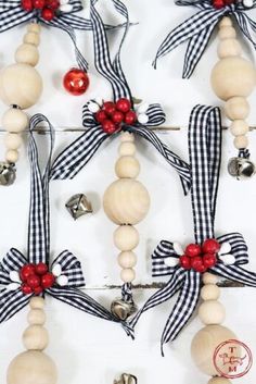 an assortment of wooden beads and bells on a white background with red, black and silver bows