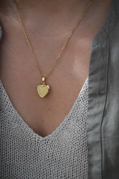 18-karat gold plated heart locket hangs on a sturdy 18-karat gold plated stainless steel chain.  Choose your chain length from the drop-down menu.   This locket is perfect for using as a keepsake necklace and is a thoughtful gift for someone special in your life. You can choose the locket as is, without photos, or have it personalized with your photo (s) and engraved your birth flower. You choose your options at checkout.  A mock-up of the photo will be done for your approval. Once approved, I w Elegant Brass Jewelry With Heart Charm, Brass Heart Charm Pendant Jewelry, Gold Heart Necklace With Round Pendant, Brass Heart Pendant Wedding Jewelry, Gold Necklace With Heart Charm And Round Pendant, Brass Heart Pendant Jewelry For Wedding, Heirloom Heart-shaped Yellow Gold Jewelry, Dainty Heart-shaped Brass Jewelry, Dainty Gold Plated Pendant Locket Necklace