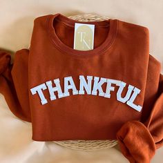 Cozy up with our Thankful Crewneck Sweatshirt this fall season!  - Sweatshirt is super soft and comfy! ♡ - Sweatshirt composition: 50% cotton, 50% polyester - All our sweatshirts run a unisex fit. They are naturally oversized, so we normally recommend your true size. But if you like a more baggy look, we recommend sizing up. - These letters are iron-on patched and is heat pressed, not embroidered. But rest assured they've been tested and won't fall off! - Please note that crewneck brand used may Thanksgiving Sweatshirt Ideas, Thankful Sweatshirt, Sweatshirt Ideas, Fall Crewneck, Thanksgiving Sweatshirt, Fall Sweater, Sweatshirt Women, Thanksgiving Gift, Comfy Sweatshirt