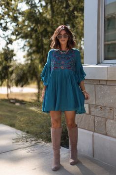 Bring a touch of playful elegance to your wardrobe with the Whimsical Teal Floral Embroidered Mini Dress! With its delicate details and flowy silhouette, this dress is perfect for any occasion that calls for a little fun and flirtation. Designed with airy bell sleeves, this dress offers a romantic and free-spirited feel. Featuring beautiful floral embroidery, this dress brings a whimsical, boho charm to your look. Pair it with your favorite boots for an effortlessly chic look that's ready for any adventure. Flowy Floral Embroidered Dress, Chic Floral Embroidered Dresses For Fall, Fall Mini Length Rayon Dresses, Embroidered Midi Dresses For Fall, Casual Flowy Floral Embroidered Dresses, Fall Rayon Mini Dresses, Flowy Embroidered Dress With Floral Details, Bohemian Mini Dress For Garden Party In Fall, Fall Bohemian Mini Dress For Garden Party