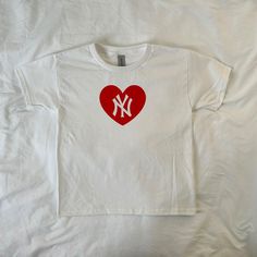 Screen printed on a made to order basis. Handmade with silk screen process, tops may have minor imperfections!⛄️ (I use Gildan Unisex Youth tees for that perfect baby tee look) 100% Cotton ⚠️ -Machine wash cold and hand washing is preferred but not required -please do not iron or bleach -all sales are final Cotton Heart Print T-shirt For Streetwear, Casual Heart Print T-shirt For Streetwear, White Tops For Baseball Season Streetwear, White Heart Print Top For Streetwear, Cotton Streetwear Top With Heart Shape, Cotton Heart-shaped Top For Streetwear, Red Heart Graphic T-shirt For Streetwear, Heart-shaped Graphic Print T-shirt For Streetwear, Streetwear Graphic Tee With Heart Graphic