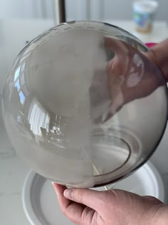 a person is holding a glass ball in their hand