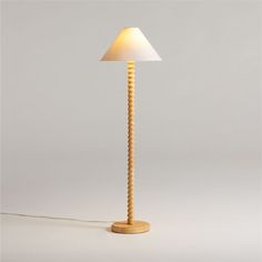 a wooden lamp with a white shade on it's head and cord attached to the base