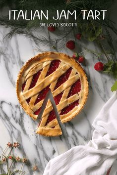 a pie sitting on top of a marble counter next to berries and greenery with the title italian jam tart she loves biscotti